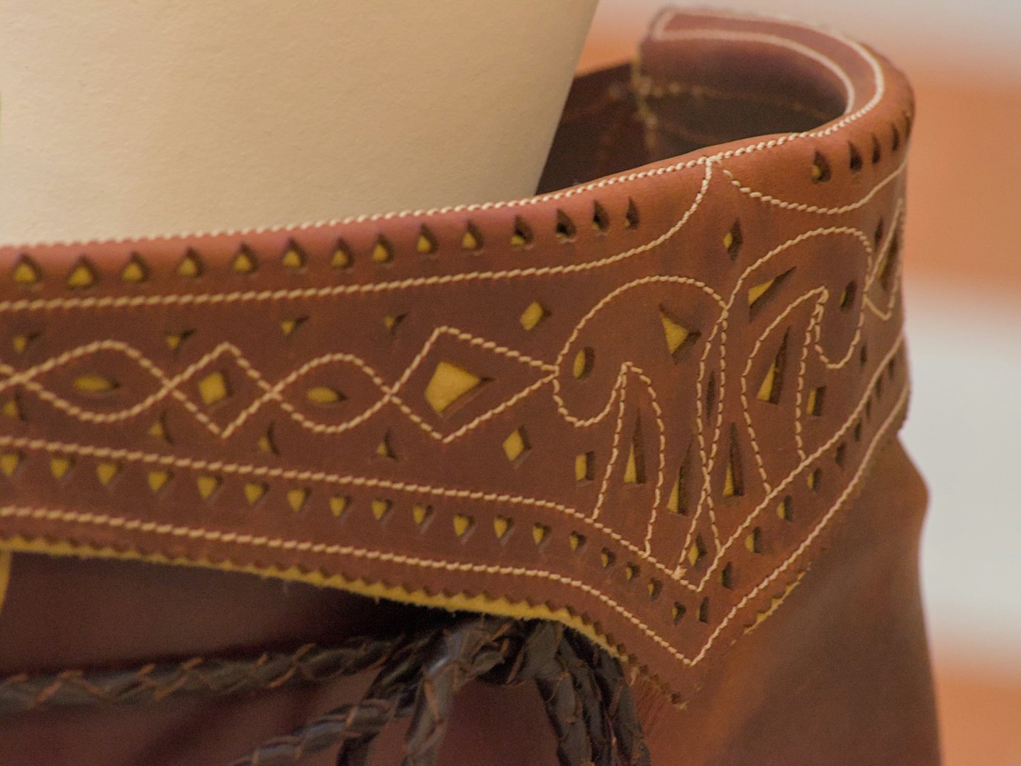 Brown leather with white stitching and yellow cut-out patterns.