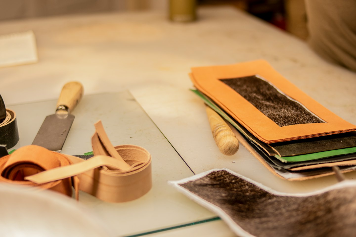 Leatherworking tools and materials arranged on a workbench.